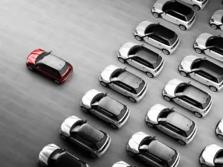 fleet of white cars with one red car in front