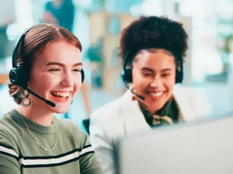 two women laughing wearing headset